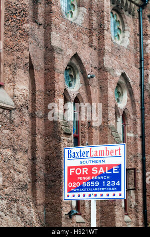 For Sale sign outside concrete New Church in Anerley, South London. Built in concrete using Portland cement & pink dye in 1883. Stock Photo