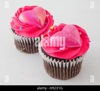 Two chocolate cupcakes on white with pink frosting Stock Photo