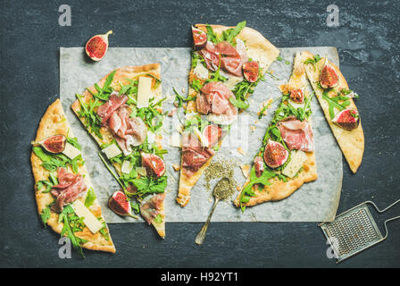 Fig, prosciutto, arugula and sage flatbread pizza on dark background Stock Photo