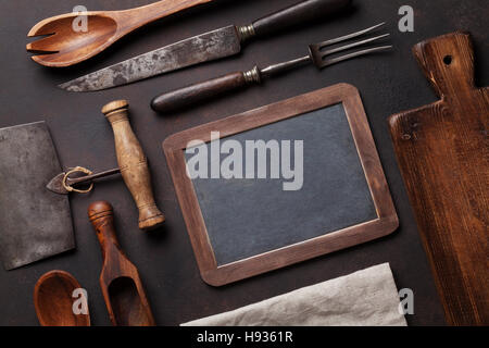 Old vintage kitchen utensils. Fork, knife, cutting board. Top view with chalk board for copy space Stock Photo