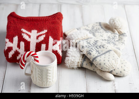 Knitted cup and winter clothes Stock Photo