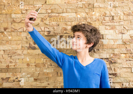 10 years old boy taking a selfie picture using a mobile phone camera Stock Photo
