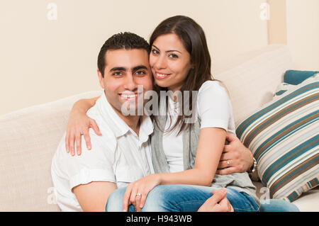 Happy couple sitting together on the sofa Stock Photo