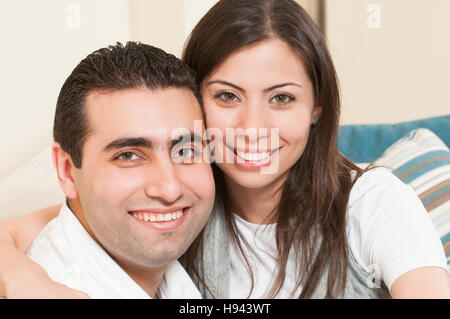 Happy couple sitting together on the sofa Stock Photo