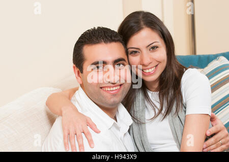 Happy couple sitting together on the sofa Stock Photo