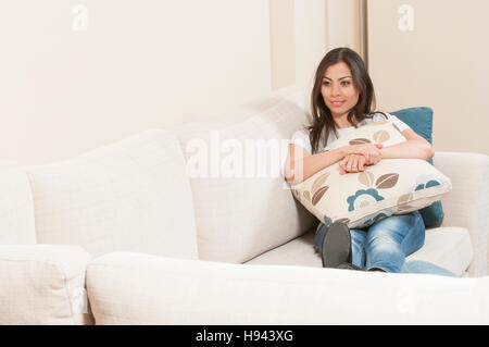 Portrait of a young woman sitting on the sofa Stock Photo