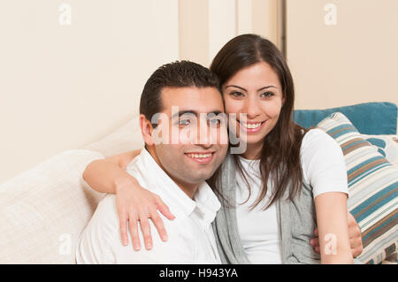 Happy couple sitting together on the sofa Stock Photo