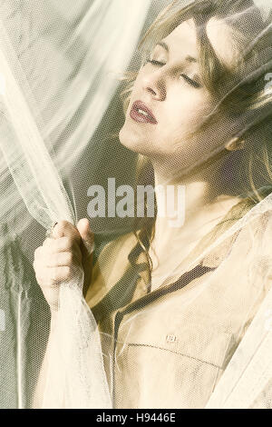 Beautiful young blond woman hand grabbing the blinds Stock Photo
