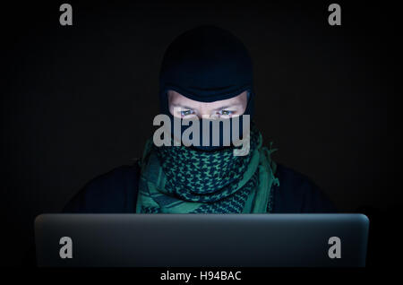 Terrorist working on his computer. Concept about international crisis, war and terrorism Stock Photo