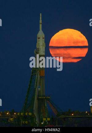 The orange supermoon rises behind the Russian Soyuz rocket and Soyuz MS-03 spacecraft sitting at the Baikonur Cosmodrome launch pad in preparation for NASA International Space Station Expedition 50 November 14, 2016 in Baikonur, Kazakhstan. Stock Photo