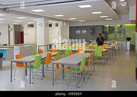 newly refurbished school dining room set out with white tables and orange and lime green timber chairs Stock Photo