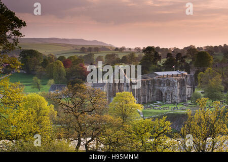Red, sunset sky over the River Wharfe, scenic priory ruins and beautiful Yorkshire Dales countryside - Bolton Abbey, North Yorkshire, England, UK. Stock Photo