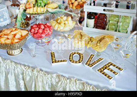 Wedding reception, sweets, drinks and fruits. Word love with olives Stock Photo