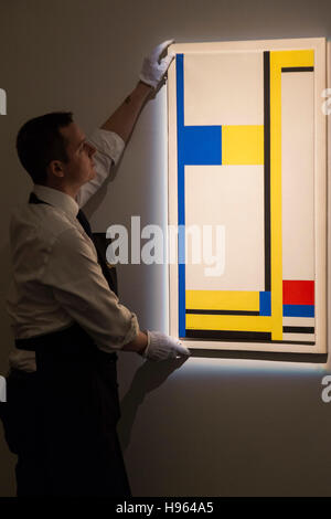 London, UK. 18 November 2016. A Sotheby's technician is handling the painting Composition Yellow, Blue, Black, Red and White by Marlow Moss, est. GBP 60,000-80,000. Sotheby's presents a preview of Modern & Post-War British Art at their New Bond Street premises. The auction will take place on 22-23 November 2016 in London. Stock Photo