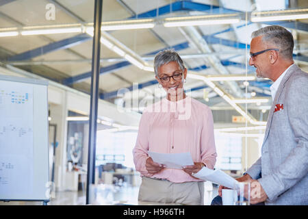 Businessman and businesswoman discussing paperwork Stock Photo