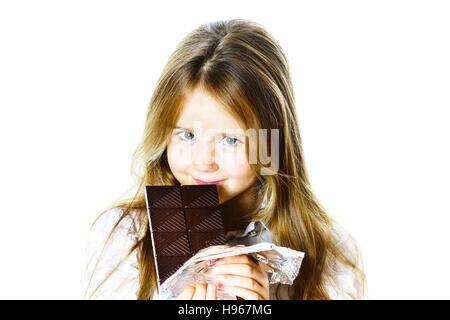 Cute little girl eating tablet of chocolate, isolated on white background Stock Photo