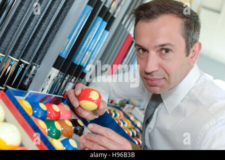 serious man prepares balls for start of game billiard Stock Photo