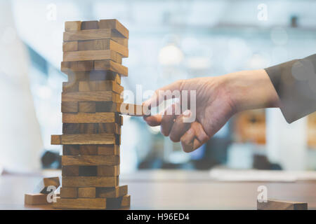 planning, risk and strategy in business, businessman gambling placing wooden block on a tower Stock Photo