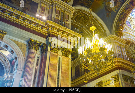 The massive chandelier and richly decorated walls of St Isaac's Cathedral with stone, painted, carved and gilt elements Stock Photo