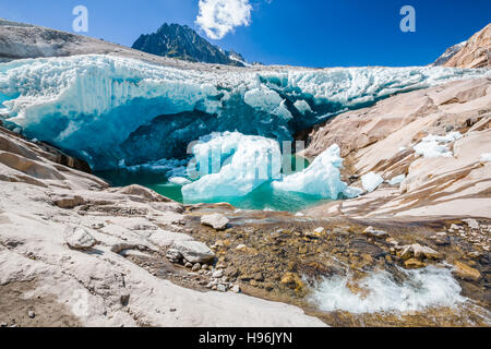 Water flows under the side of Aletsch glacier, which is meltint Stock Photo