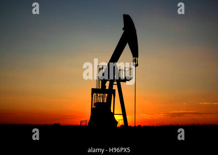 An industrial pumpjack in the sunset Stock Photo