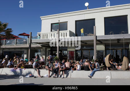 People sitting in and in front of a beach cafe in St. Kilda, a suburb of Melbourne, Victoria, Australia Stock Photo