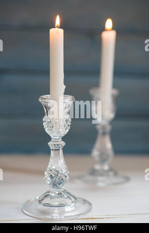 Two glass candlesticks with lit candles Stock Photo