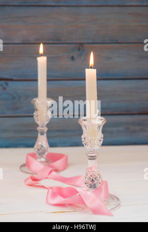 Two glass candlesticks with lit candles Stock Photo