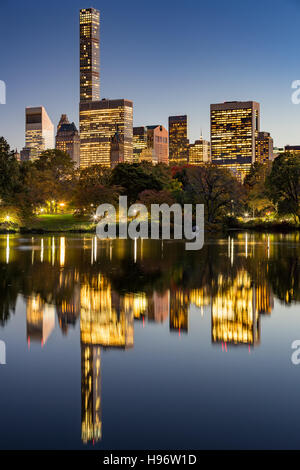 The Lake in Central Park at twilight with New York City lights and Manhattan Midtown skyscrapers reflecting into the lake Stock Photo