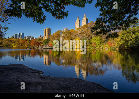 Fall in Central Park at The Lake. Cityscape sunrise view with colorful Autumn foliage on the Upper West Side. New York City Stock Photo