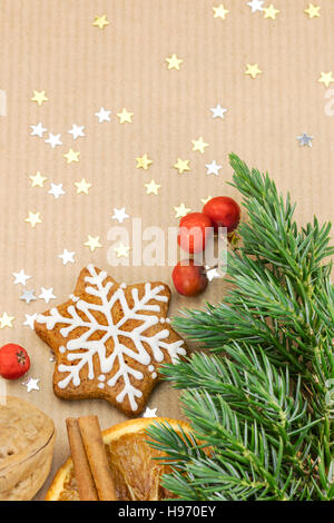 christmas cookies, spices, nut and red berries on brown wrapping paper background Stock Photo