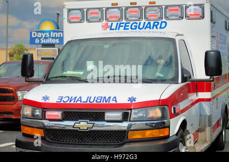 An ambulance speeding down the road with red flashing lights. Stock Photo