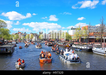 APRIL 27: Amsterdam canals full of boats and people in orange during the celebration of kings day on April 27, 2015 in Amsterdam, The Netherlands Stock Photo