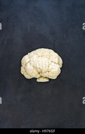Half the white cauliflower isolated on dark gray slate stone background Stock Photo
