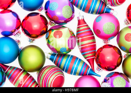 Bright vivid background of assorted Christmas ornaments with polka dot and striped patterns in a random pattern on white in a full frame view Stock Photo