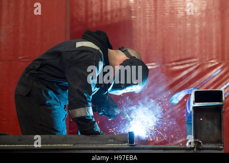 A male welder welding steel metal in a workshop. Stock Photo