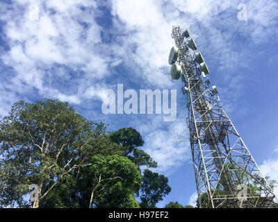 Common communication tower, cellphone tower against blue sky and clouds in Forbes, Tawau, Malaysia. Stock Photo