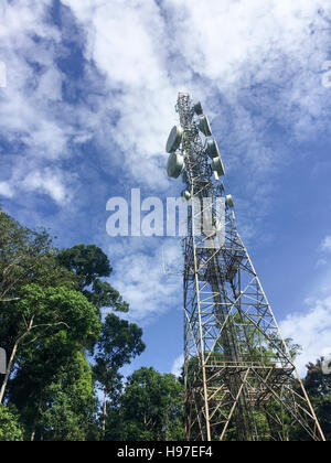 Common communication tower, cellphone tower against blue sky and clouds in Forbes, Tawau, Malaysia. Stock Photo