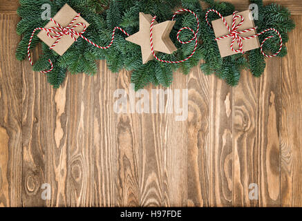 Christmas tree branches and gift boxes on rustic wooden background. Vintage style toned picture Stock Photo