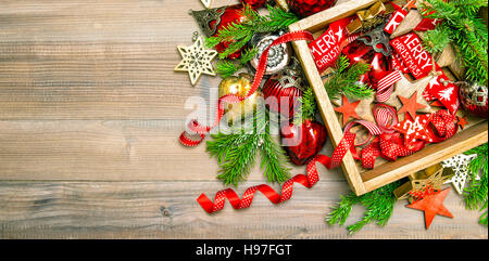 Christmas decorations, toys and ornaments with christmas tree branches. Red stars, baubles, ribbons. Vibrant colors Stock Photo