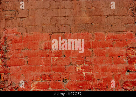 Old brick wall half painted in deep red, half in brown. Abstract background old red-brown brick wall Stock Photo