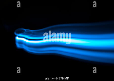 Blue and white streaks of light over black background with copy space for concept about natural gas Stock Photo