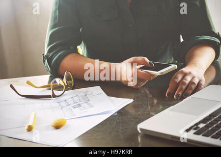 Architect woman working at computer and calling her client Stock Photo