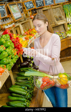 Young woman at greengrocer's buying fresh fruits and vegetables Stock ...