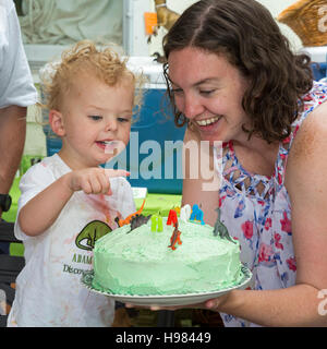Denver, Colorado - Adam Hjermstad Jr. points to the dinosaurs on the cake at his second birthday party. Stock Photo