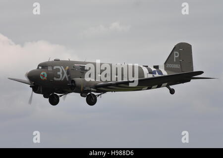 Douglas C-47A Skytrain, military version of the DC-3 Dakota,in USAAF D-Day markings making a flypast at Abingdon, UK Stock Photo