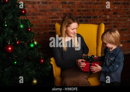 https://l450v.alamy.com/450v/h98dfe/mom-gives-a-child-christmas-gift-h98dfe.jpg