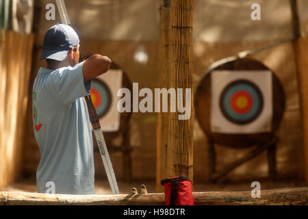 Man practising archery at Carew Castle, Pembrokeshire, Wales, United Kingdom Stock Photo