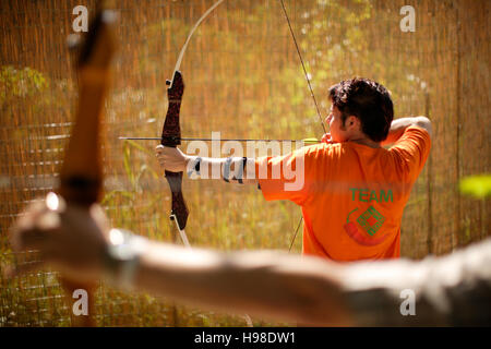 Man practising archery at Carew Castle, Pembrokeshire, Wales, United Kingdom Stock Photo