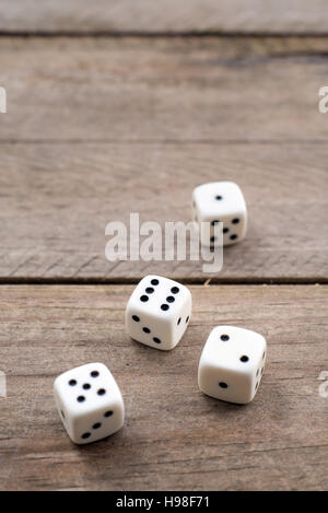 Four white dice on wooden background Stock Photo